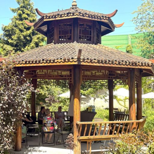 Der Holzpavillon in Pagodenoptik im sommerlichen Garten der Löwenherz-Akademie