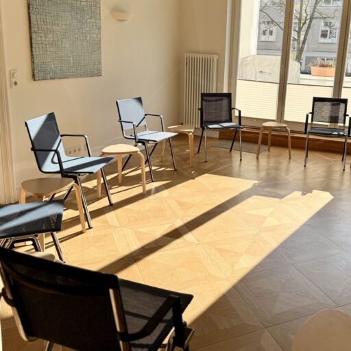Der Seminarraum der Löwenherz-Akademie mit einem Stuhlkreis auf Holzparkett, die Sonne scheint durch das Fenster