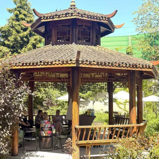 Der Holzpavillon in Pagodenoptik im sommerlichen Garten der Löwenherz-Akademie