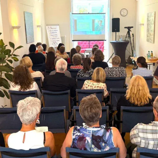 Der Seminarraum der Löwenherz-Akademie, in dem viele Menschen eine Präsentation betrachten